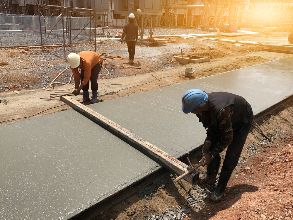 Two workers are working to resurfacing a concrete floor in a commercial area