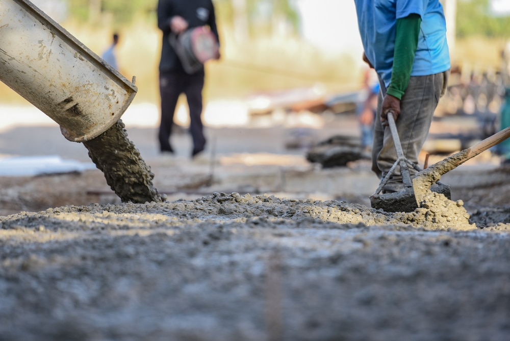 Workers are pouring concrete and resurfacing it to install new sidewalk