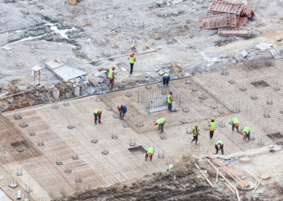 Workers are working to construct a foundation for commercial building.