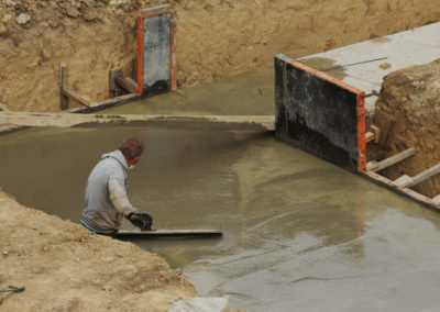 A worker is resurfacing concrete foundation , Los angeles