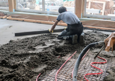 A worker is working to resurface a concrete floor of a commercial building, Los Angeles