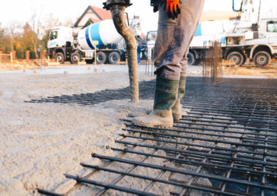 Workers are installing concrete in a underconstruction commercial space