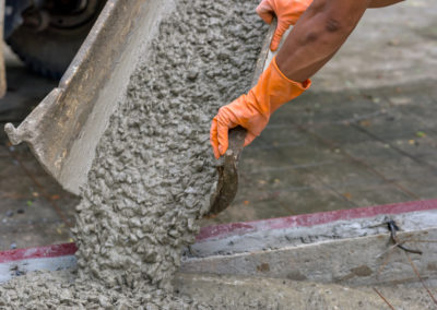 A worker is pouring concrete for constructing a sidewalk, Los Angeles