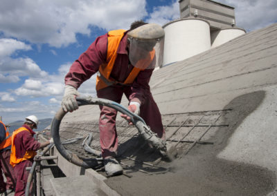 Workers are replacing concrete on a rooftop