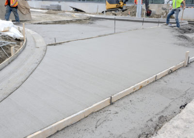 Workers are constructing concrete sidewalk using wood beam in Los angeles