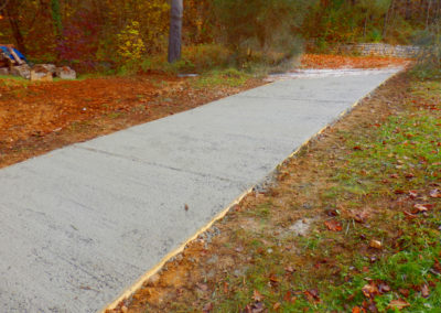 Newly installed concrete driveway paving in a garden.