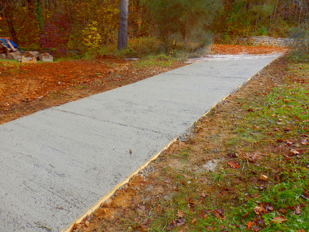 Newly installed concrete driveway paving in a garden.