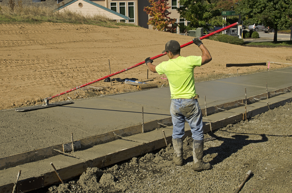 A worker is resurfacing a concrete driveway in Los Angeles