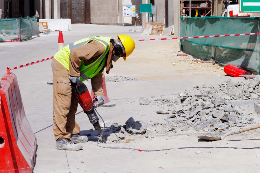 A worker is resurfacing a concrete driveway in Los Angeles